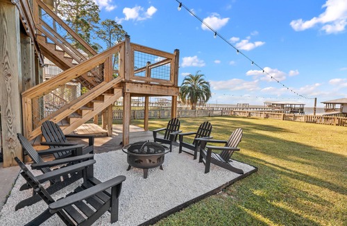 Alabama Gulf Coast House | A charming waterfront getaway on Mobile Bay featuring a private pier, cozy outdoor spaces, and beautiful bay views.