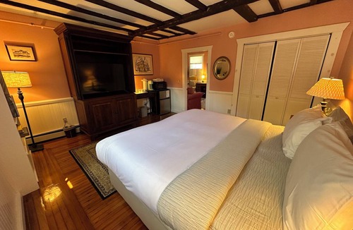 Newport Hotel | Step back in time with modern comfort in this charming exposed beam, private suite in Historic downtown Newport RI! King bed + pull-out sofa, ensuite bath, gas fireplace, AC, TV, mini fridge, coffee station. Steps to Thames Street, shops, wharfs