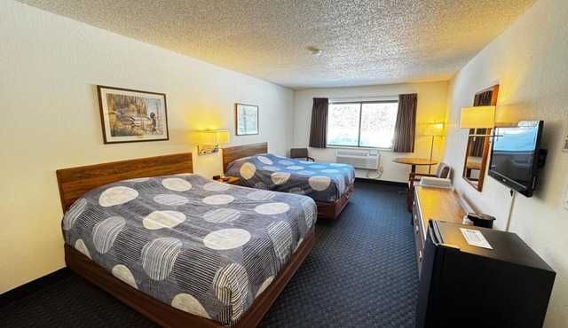 A dog friendly room with two queen beds, private bathroom, mini fridge, and single-serve coffee maker.